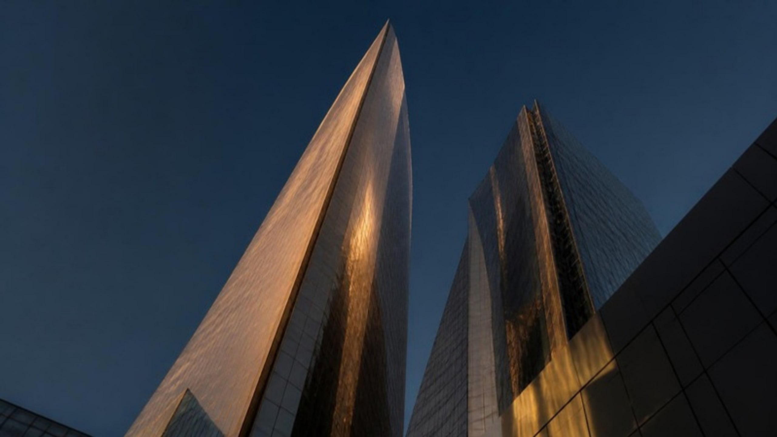 Modern glass towers against a deep blue dusk sky
